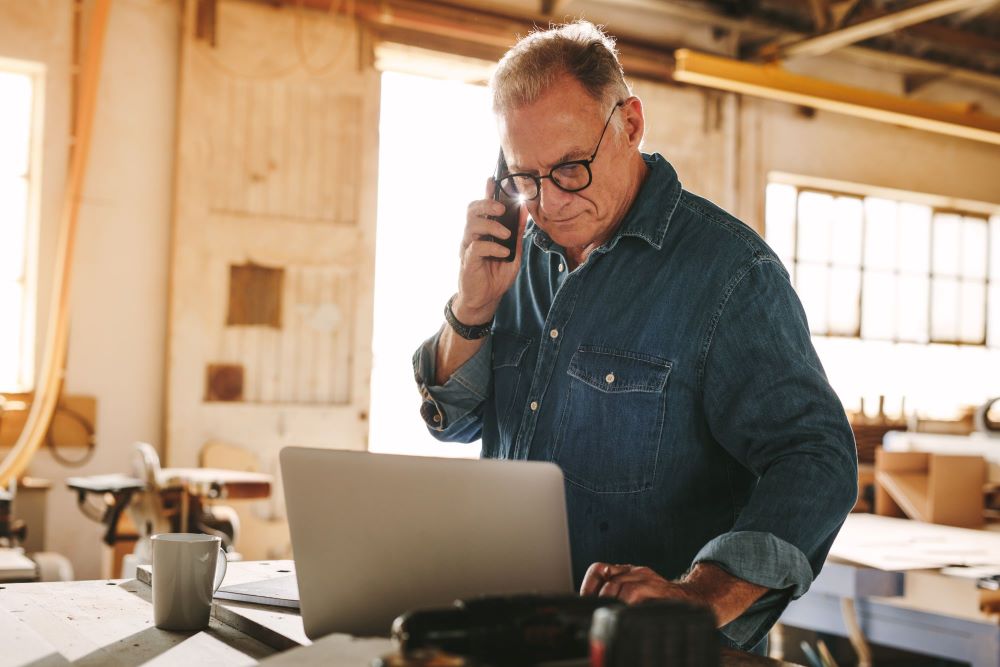 Business owner on a phone inside of his workshop